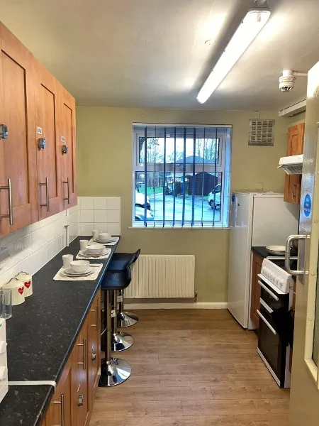A kitchen in standard accommodation on City Campus, with cupboards, worktops, a hob, an oven and a fridge/freezer