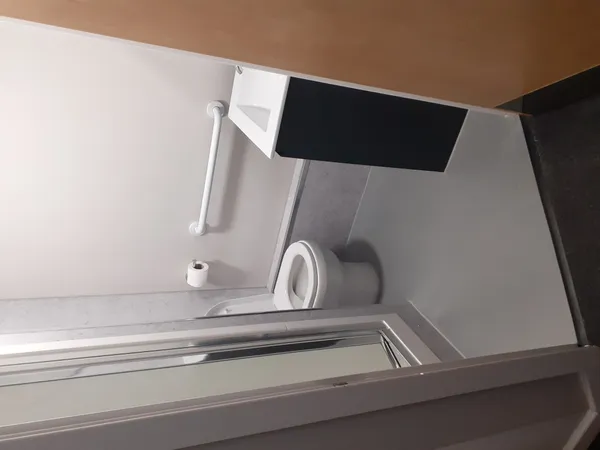 Photograph of an ensuite bathroom in Walsall Campus accommodation: a toilet, sink, shower and towel rail.