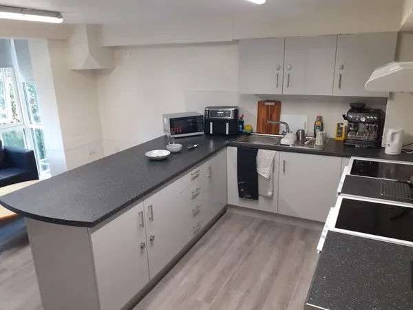 Photograph of a communal kitchen in Walsall Campus accommodation: a countertop with a microwave, air fryer, coffee maker and kettle.