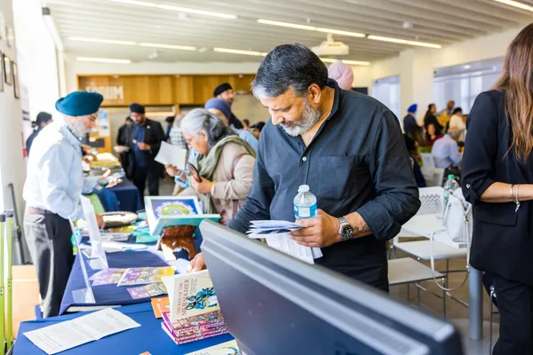 Thumbnail Image from the Research in Sikh Studies Conference June 2023 showing attendants examining resources at pop-up stands
