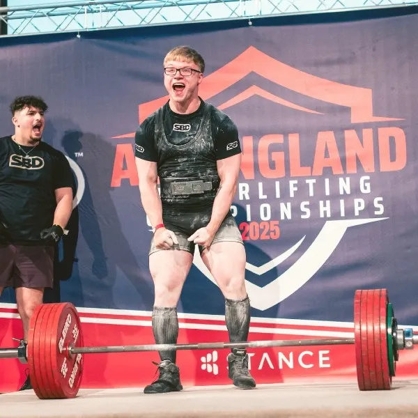 Image of a student lifting a large weight