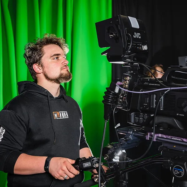 Student operating a camera in the TV studio