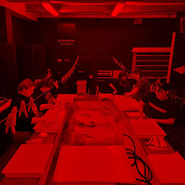 Photography student developing a black and white image in the photography darkroom.
