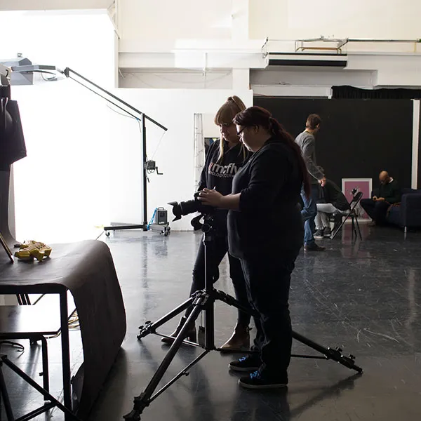 2 Photography students setting up a photoshoot in the large photography studio