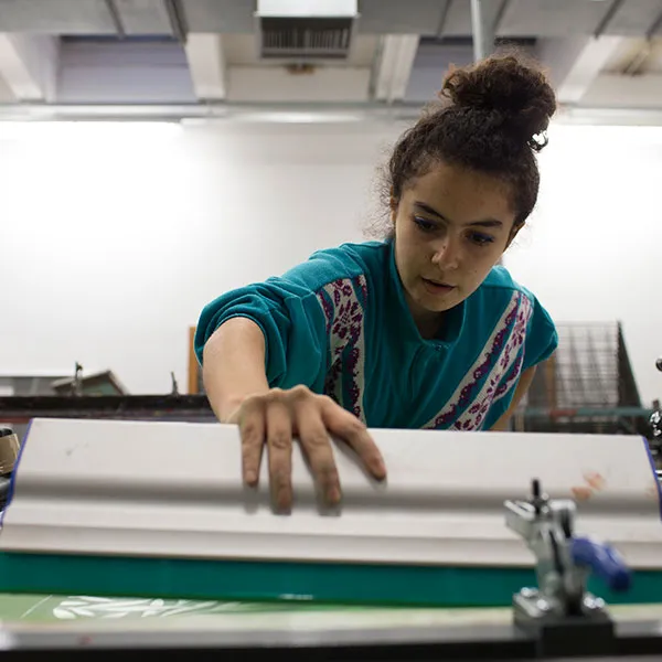 Female student printing in the the screen printing studio.