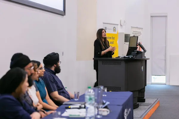 Thumbnail Image from the Research in Sikh Studies Conference June 2023 showing a panel of speakers at the front of a lecture room giving a presentation