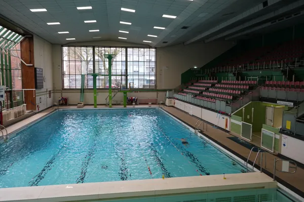 A swimming pool at Gala Leisure Centre with diving boards and rows of crowd seating