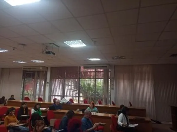 A lecture room with participants sat in chairs reading and writing