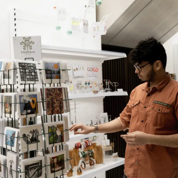 A student in the art gallery shop examining the rotating display