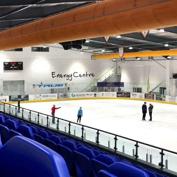 Telford Ice Rink with four people skating on the ice, the words ENERGY CENTRE printed onto the far wall