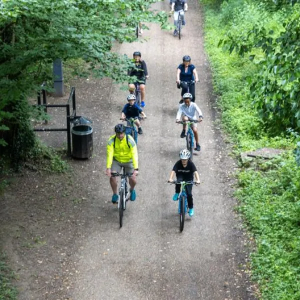 Cyclists in Telford riding together through a grassy path, six in close formation while two more follow behind