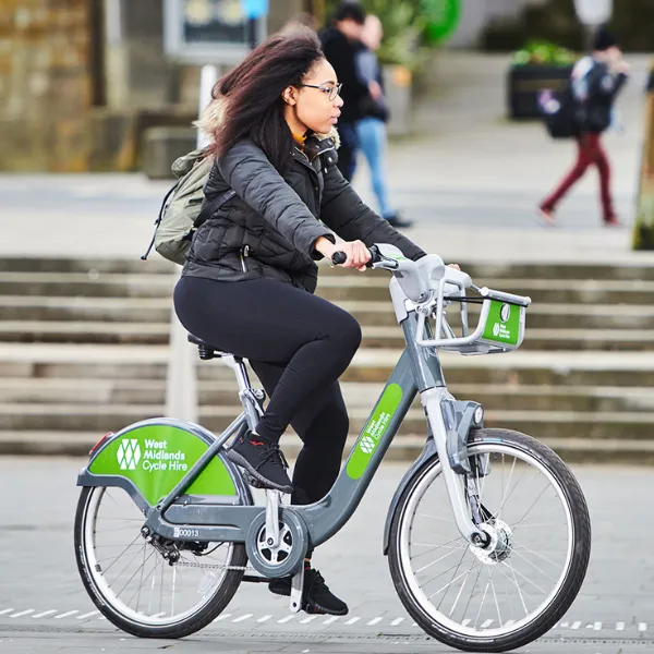 A student riding a hired bicycle with West Midlands Cycle Hire branding