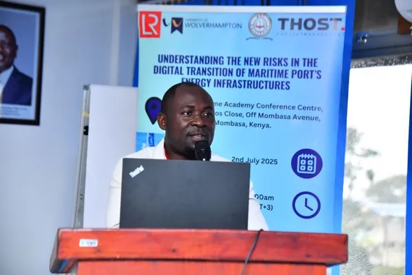 Photograph of a speaker in a white shirt at a lectern.