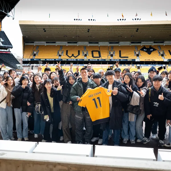 Group of Wolves fans posing with Hwang Hee Chan and his Wolves club shirt