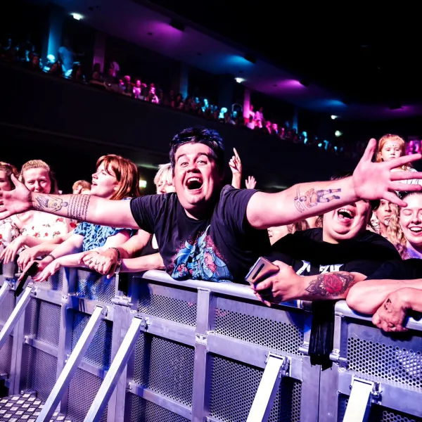 Fans against a barrier watching a performance in The Halls