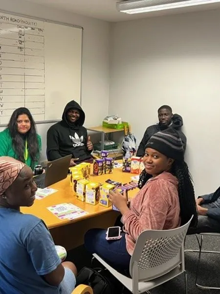A group of students sat together at a table with an array of snacks