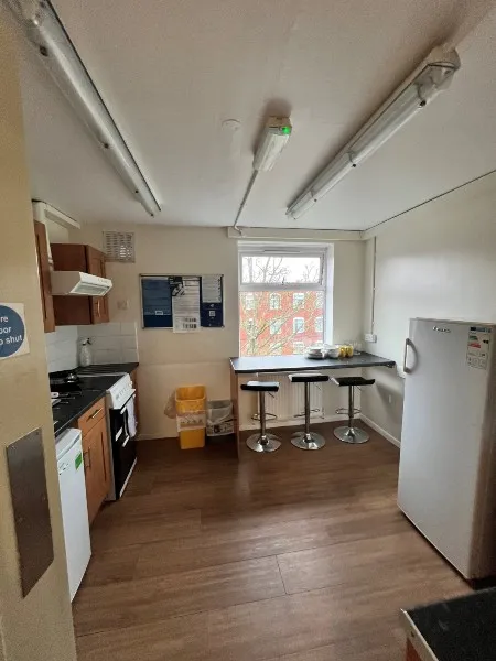 A kitchen in standard accommodation on City Campus, with cupboards, worktops, a hob, an oven and a fridge/freezer
