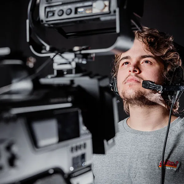 Student operating a camera in the TV studio