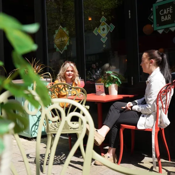 Two people sitting at a table outside the Lupo Lounge restaurant