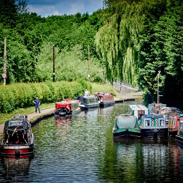 A canal in Wolverhampton with people standing on the banks and boats in the water