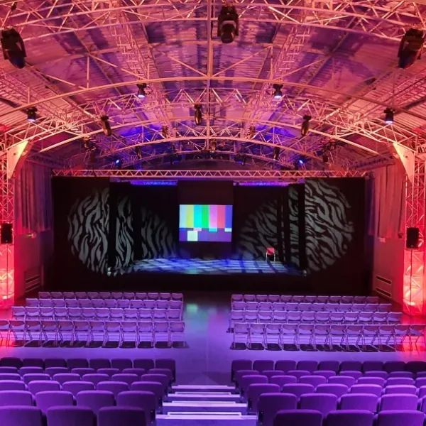 Inside Walsall Arena: Rows of seats in front of a stage with a digital screen