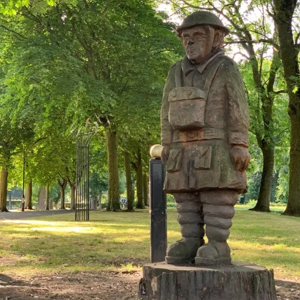 Statue of a soldier in Willenhall Memorial Park, standing to attention on a plinth
